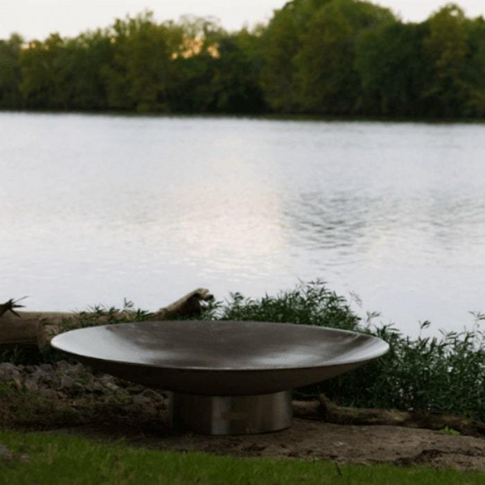 Bella Vita 58.5" Stainless Steel Fire Pit by Fire Pit Art with Pond Background