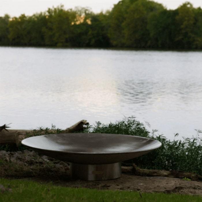 Bella Vita 70" Stainless Steel Fire Pit by Fire Pit Art with Big Pond Background