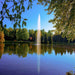 Image of the Scott Aerator Gusher Pond Fountain 1.5HP in a Pond Shooting High Water with Many Trees