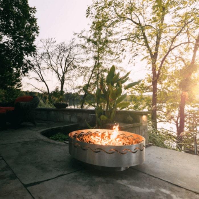 Fire Surfer Stainless Steel Fire Pit by Fire Pit Art with Tress Background