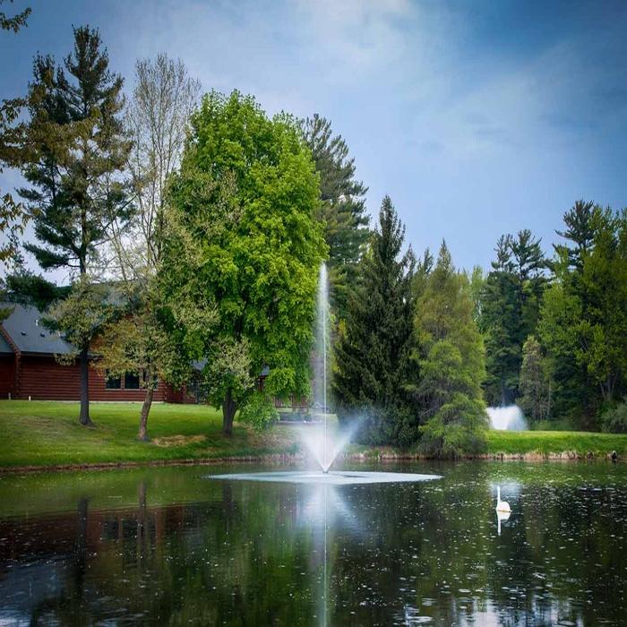 Scott Aerator Skyward Pond Fountain 1.5HP 230V with a House and Trees Background